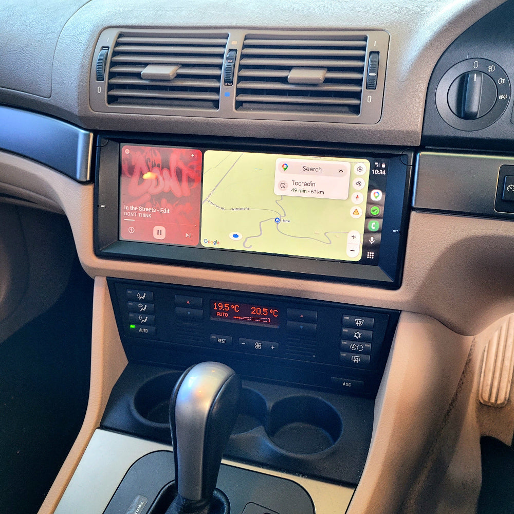 BMW E39 dashboard with touchscreen display showing navigation and temperature controls.